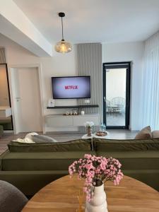 Una sala de estar con un sofá y un televisor. en Green Velvet Studio, en Brasov