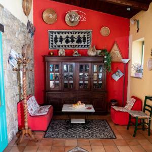 uma sala de estar com paredes vermelhas e uma mesa e cadeiras em Hotel Sa Lolla em Barumini