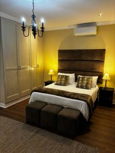 a bedroom with a large bed and a chandelier at Sunset Waves Bloubergstrand in Sunset Beach