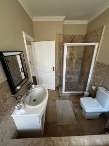a bathroom with a sink and a toilet and a shower at Sunset Waves Bloubergstrand in Sunset Beach