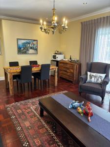 a living room with a table and a dining room at Sunset Waves Bloubergstrand in Sunset Beach