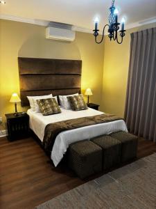 a bedroom with a large bed and a chandelier at Sunset Waves Bloubergstrand in Sunset Beach
