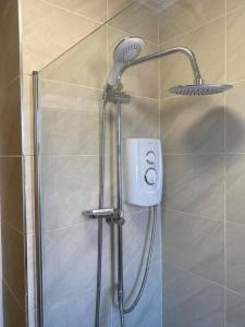 a shower with a shower head in a bathroom at The Gold- Home away from home in Manchester