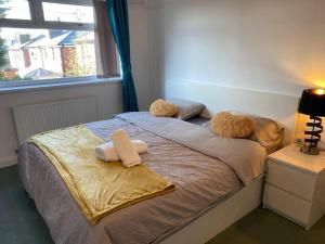 a bedroom with a bed with two towels on it at The Gold- Home away from home in Manchester