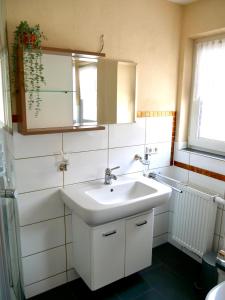 bagno con lavandino bianco e specchio di CasaJansen - Große Wohnung im Dreistädte-Eck a Norimberga