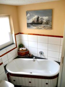 un bagno con vasca e foto appese alla parete di CasaJansen - Große Wohnung im Dreistädte-Eck a Norimberga