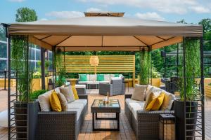 une grande terrasse avec des canapés et un parasol dans l'établissement Novotel Budapest City, à Budapest