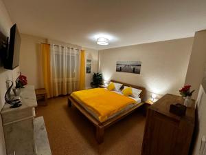 een slaapkamer met een bed met een gele deken bij CATS Home in Bottrop