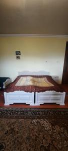 1 dormitorio con 1 cama grande con marco blanco en The Lichk Lodge en Lichkʼ