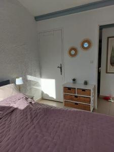 ein Schlafzimmer mit einem Bett mit einer lila Tagesdecke in der Unterkunft La Cigale du Pas du Ventoux en Provence in Mollans-sur-Ouvèze