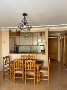 - une cuisine avec une table à manger et des chaises dans l'établissement BERMUDAS-TURIS Apartamentos, à Benidorm