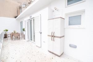 Un pasillo blanco con una puerta y una mesa en Marilora's House. Charming Urban Retreat, en Atenas
