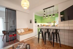 una cocina con barra y algunos taburetes en una habitación en Marilora's House. Charming Urban Retreat, en Atenas