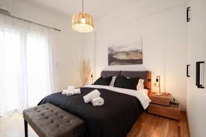 1 dormitorio con 1 cama negra grande con silla en Marilora's House. Charming Urban Retreat, en Atenas