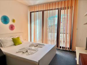 a bedroom with a white bed with a large window at Menada Apartments in Marina Cape in Aheloy +37 photos