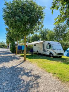 a caravan parked in a field next to a tree at Seregnér Agricamping - Adults Only 18 - solo piazzole libere per camper, tende e roulotte in Monzambano