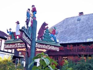 a street sign with statues on top of a building at Haslehaus in Feldberg