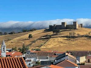 una ciudad con un castillo en la cima de una colina en Casa Rural La Pariente en El Real de la Jara