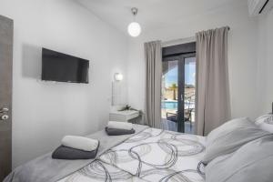 ein Schlafzimmer mit einem großen Bett und einem TV an der Wand in der Unterkunft Villa Dalmatinac in Murvica