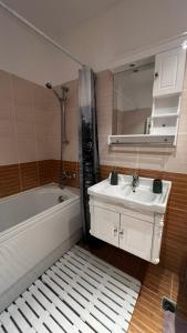 ein Badezimmer mit einem Waschbecken, einer Badewanne und einem Spiegel in der Unterkunft Premium Studio in Borovets in Borowez