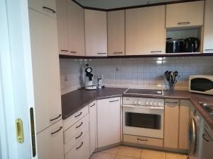 uma cozinha com armários brancos e um forno com placa de fogão em Stricker em Markelfingen