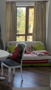 1 dormitorio con 1 cama, 1 silla y 1 ventana en Premium Studio in Borovets, en Borovets