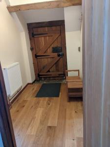 a room with a barn door and a wooden floor at The Old Granary Farm Cottage in Abergavenny