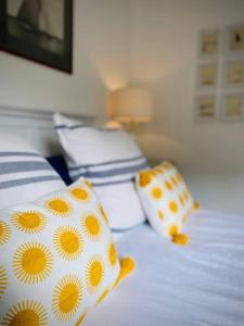 uma cama com almofadas amarelas e brancas em A Seafood and Walking Enthusiasts Quiet Escape. em West Mersea