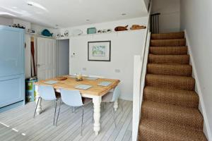 uma cozinha e sala de jantar com uma mesa e uma escada em A Seafood and Walking Enthusiasts Quiet Escape. em West Mersea