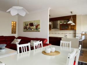 cocina y sala de estar con mesa blanca y sillas. en Darou, en Vimianzo