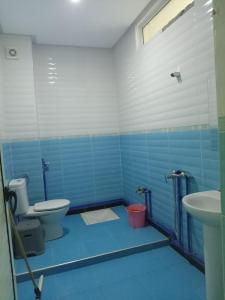 La salle de bains bleue est pourvue de toilettes et d'un lavabo. dans l'établissement Residence El Oukhowa, à Ouarzazate