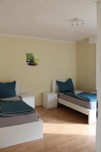 een slaapkamer met 2 bedden en blauwe kussens bij Mont Apartments in Erkrath