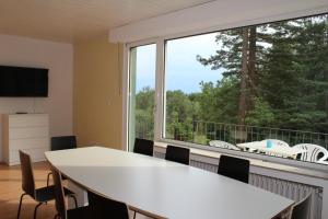 een vergaderzaal met een tafel en een groot raam bij Mont Apartments in Erkrath