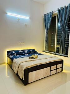a bedroom with a bed in a room with a window at Delightful Dwellings 2bhk at 16th floor@kharadi in Pune