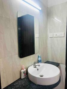 a bathroom with a white sink and a mirror at Delightful Dwellings 2bhk at 16th floor@kharadi in Pune