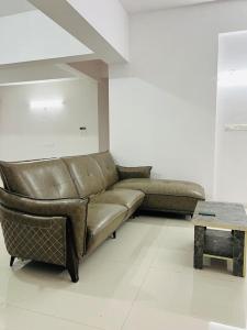 a living room with a leather couch and a table at Delightful Dwellings 2bhk at 16th floor@kharadi in Pune