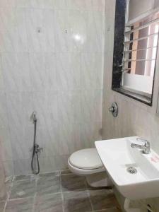 a bathroom with a white toilet and a sink at Delightful Dwellings 2bhk at 16th floor@kharadi in Pune