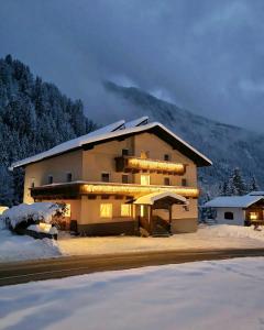 a large building with lights on it in the snow at Haus Marinus in Jerzens