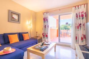 een woonkamer met een blauwe bank en een tafel bij Reserva De Marbella in Marbella
