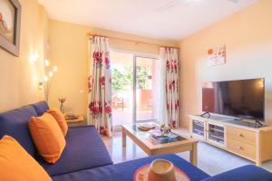 een woonkamer met een blauwe bank en een tv bij Reserva De Marbella in Marbella