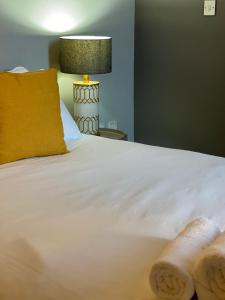 a white bed with a yellow pillow and a lamp at Go Bright Double Studio in London