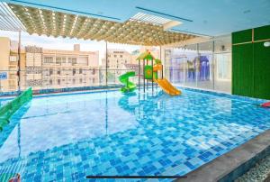 a large swimming pool with a playground in a building at Ocean Eyes - Gold Sea Vung Tau Building in Vung Tau