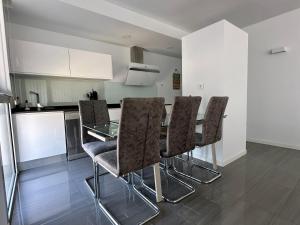 a kitchen with a glass table and chairs at PISO-DEL-PLAYA in Guardamar del Segura