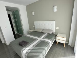 a small bedroom with a large bed and a mirror at PISO-DEL-PLAYA in Guardamar del Segura