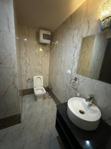 a bathroom with a sink and a toilet at Pearl Suites at Omaxe Eternity in Vrindāvan