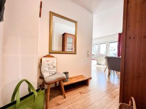 a living room with a chair and a mirror at Auszeit am Staufen in Oberstaufen