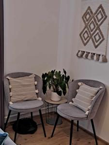 two chairs and a table with a plant in a room at Cozy Town Center Retreat in Komárno