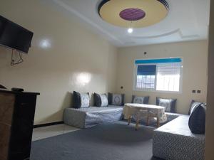 - un salon avec un canapé et une table dans l'établissement Residence El Oukhowa, à Ouarzazate