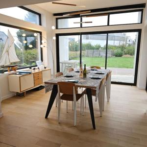 ein Esszimmer mit einem Tisch und Stühlen sowie eine Küche in der Unterkunft Villa vue Imprenable Aber Benoît in Saint-Pabu