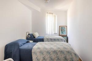 1 Schlafzimmer mit 2 blauen Betten und einem Fenster in der Unterkunft Adelaide al Borgo. in Castelnuovo di Porto